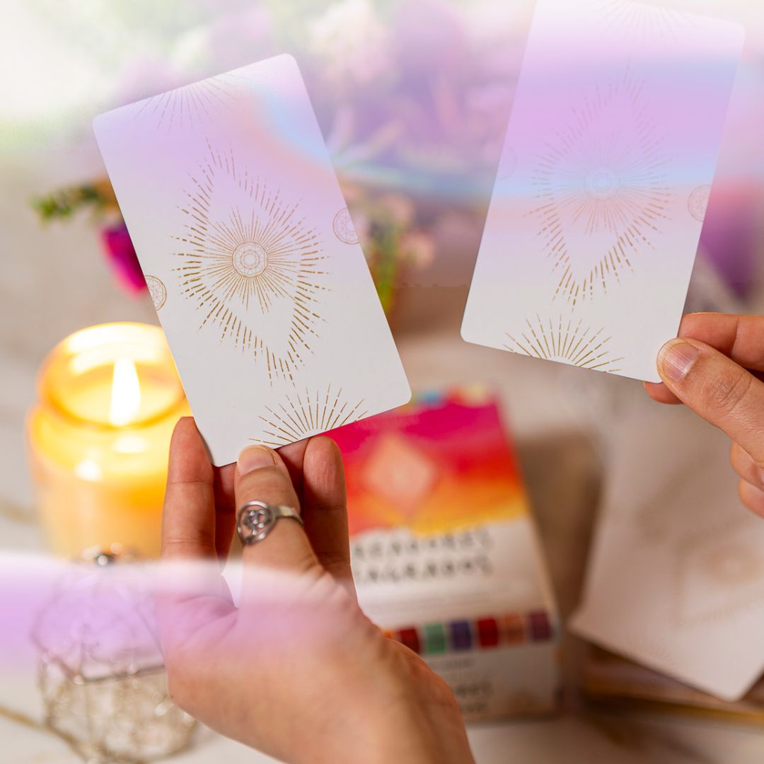 Cartas de oráculo en manos de Bea Coronel junto a velas, representando formación en tarot y oráculos